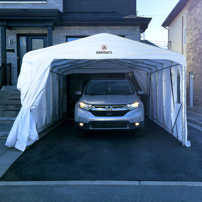 Car parked inside a white carport with 'ABRIS MTL' branding in front of a house.